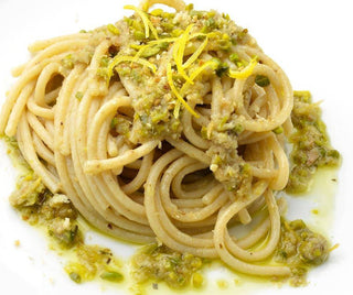 Spaghetti con acciughe, pesto e zeste di agrumi.